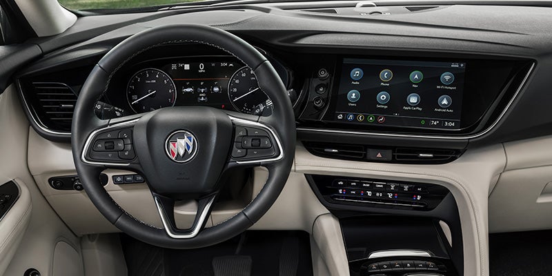 Buick vehicle interior featuring a steering wheel, digital instrument cluster, touchscreen infotainment system, and premium front cabin design
