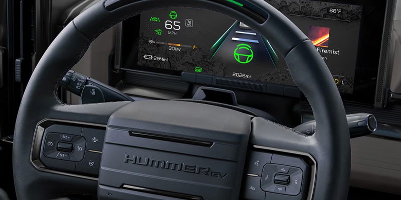 Driver's view of the GMC Hummer EV steering wheel with a digital instrument cluster displaying Super Cruise driver assistance features.