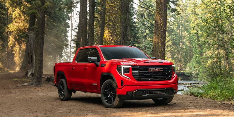 side view of GMC Sierra 1500 parked on mountain road.